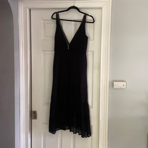 low neck and low back cute black dress with ruffle detail at the bottom.